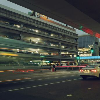 Cars passing through airport terminal drop-off area at night
