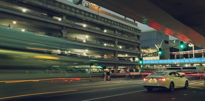 Cars passing through airport terminal drop-off area at night