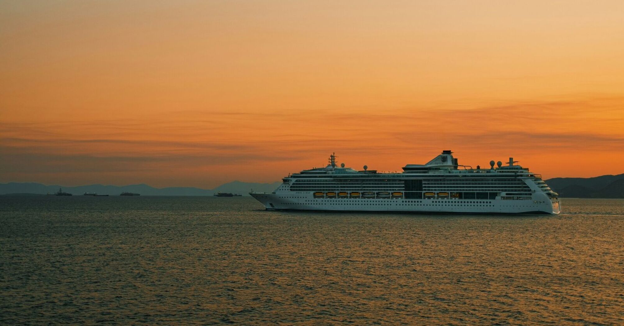 Cruise ship sailing at sunset on open sea