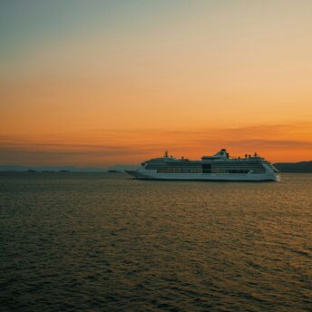 Cruise ship sailing at sunset on open sea