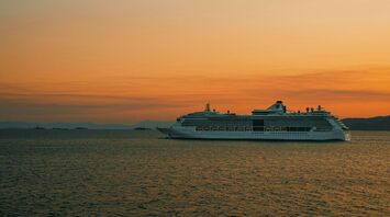 Cruise ship sailing at sunset on open sea