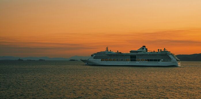 Cruise ship sailing at sunset on open sea
