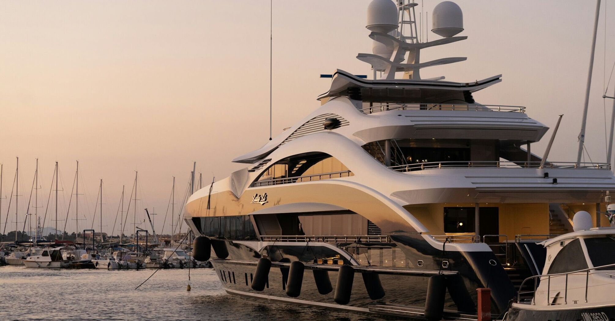 Luxury yacht moored at marina at sunset