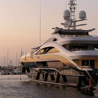Luxury yacht moored at marina at sunset