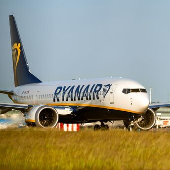 Ryanair aircraft on runway near airport buildings