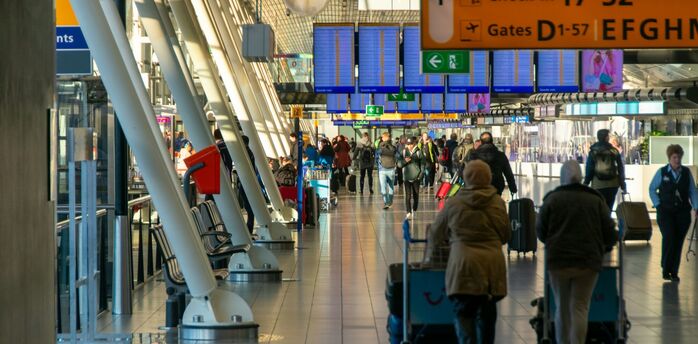 Busy airport terminal with passengers walking to departure gates