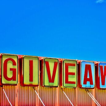 Colourful giveaway sign against blue sky