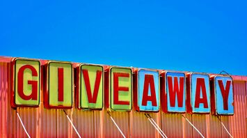 Colourful giveaway sign against blue sky