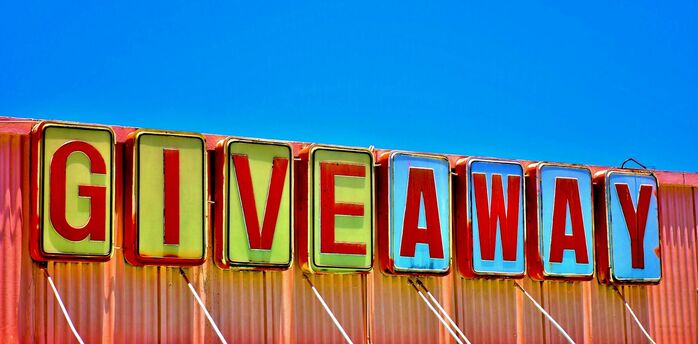 Colourful giveaway sign against blue sky