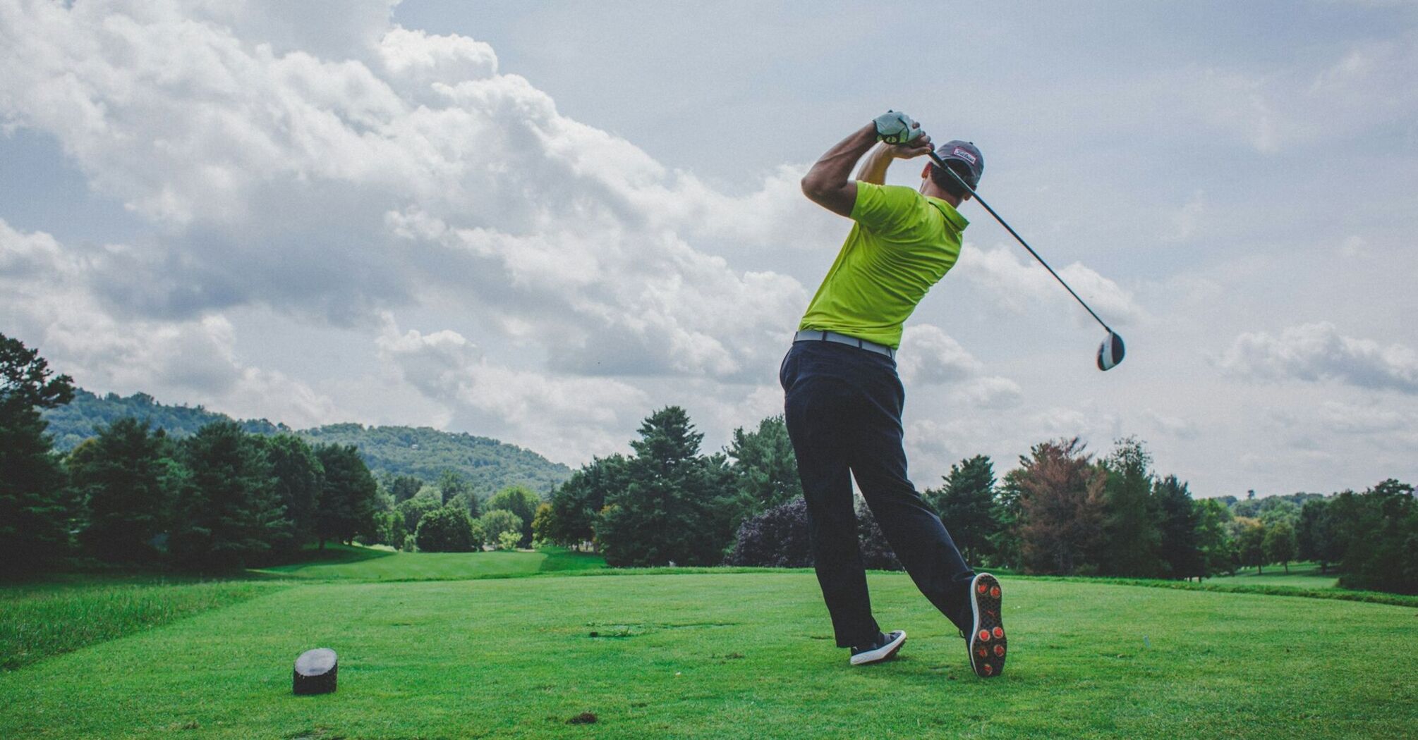 Golfer teeing off on green course