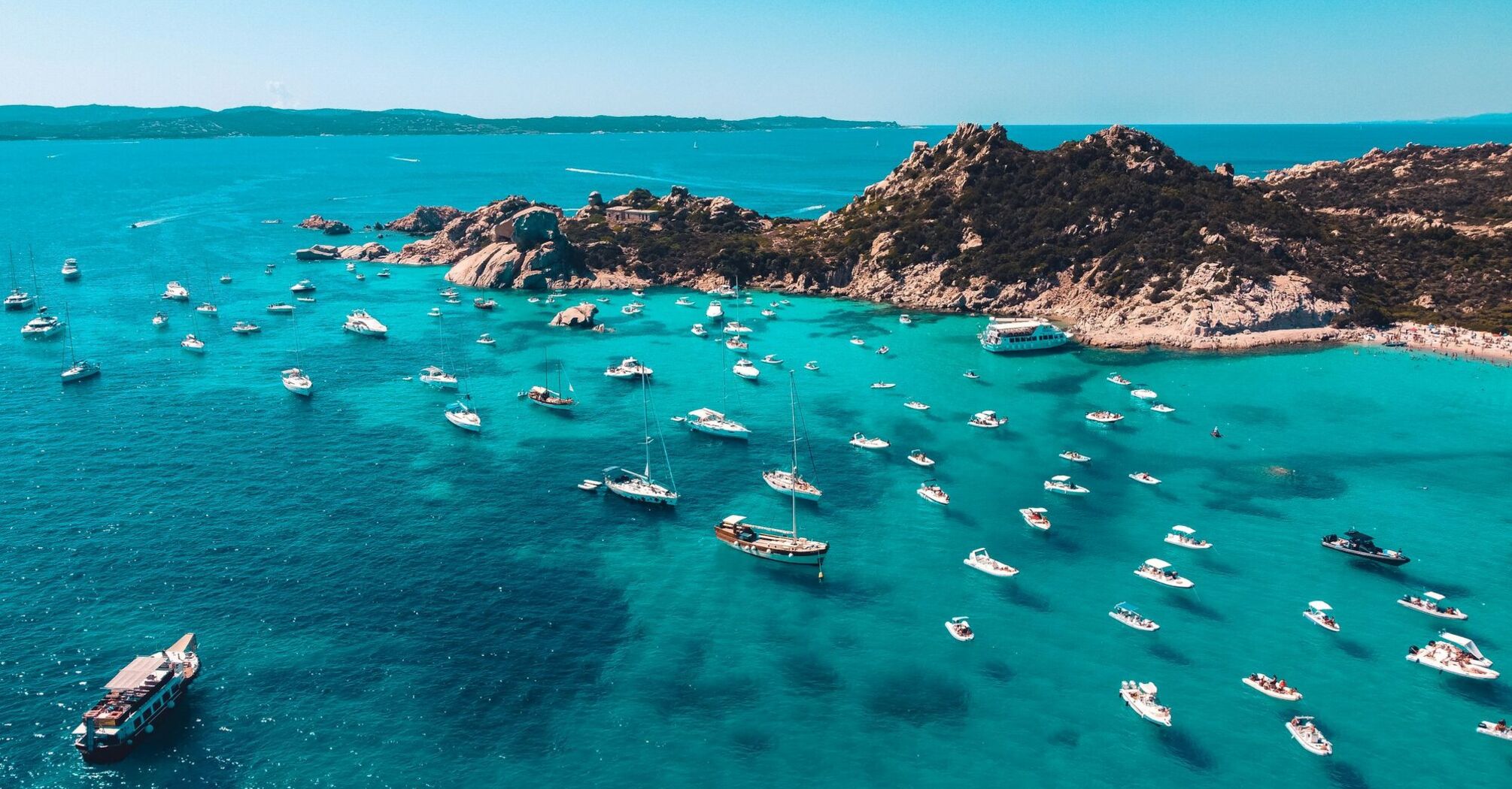 Boats anchored off Sicily rocky coastline
