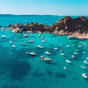 Boats anchored off Sicily rocky coastline