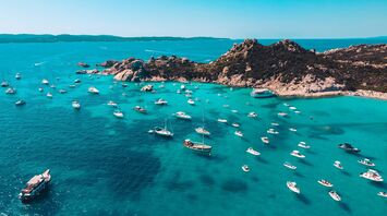 Boats anchored off Sicily rocky coastline