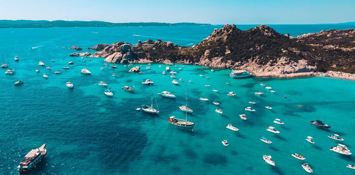 Boats anchored off Sicily rocky coastline