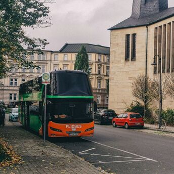 FlixBus coach stopped on city street near bus stop