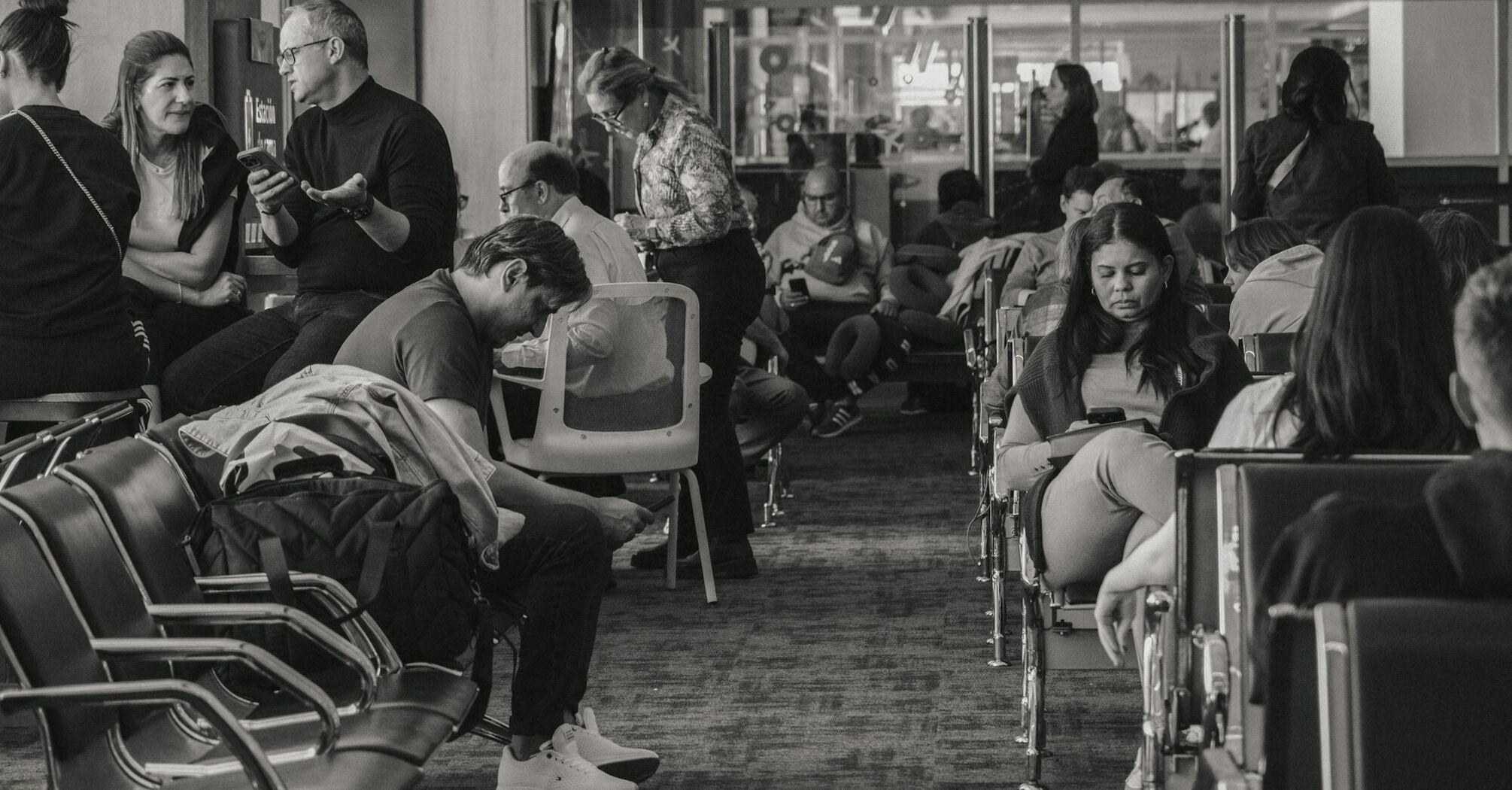 Passengers waiting inside airport terminal during flight disruption