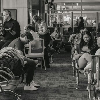 Passengers waiting inside airport terminal during flight disruption