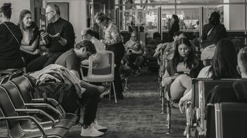 Passengers waiting inside airport terminal during flight disruption