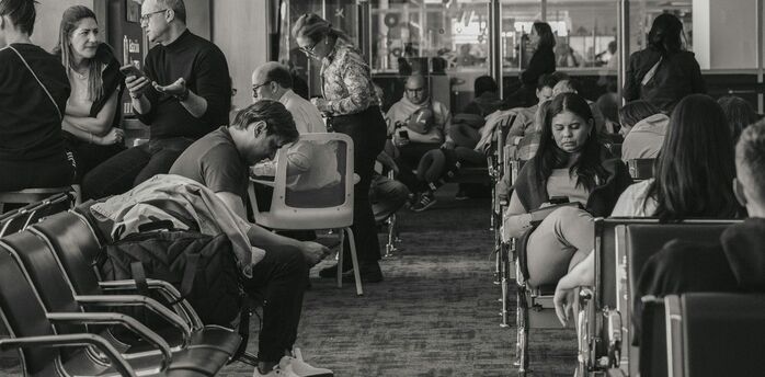 Passengers waiting inside airport terminal during flight disruption