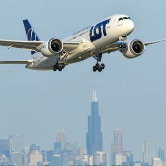 LOT Polish Airlines aircraft approaching city skyline