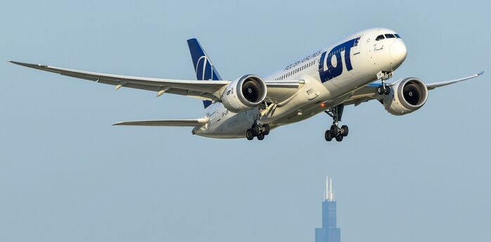 LOT Polish Airlines aircraft approaching city skyline