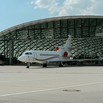 Private jet parked outside Salzburg Airport terminal hangar