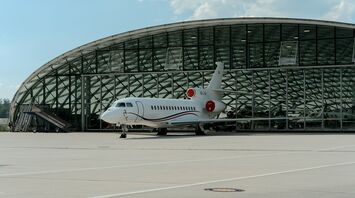 Private jet parked outside Salzburg Airport terminal hangar