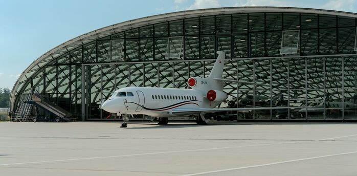 Private jet parked outside Salzburg Airport terminal hangar