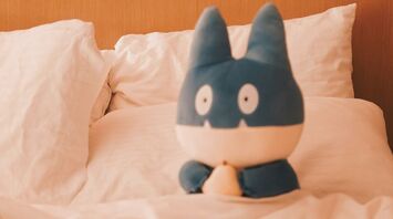 Plush toy sitting on a hotel bed