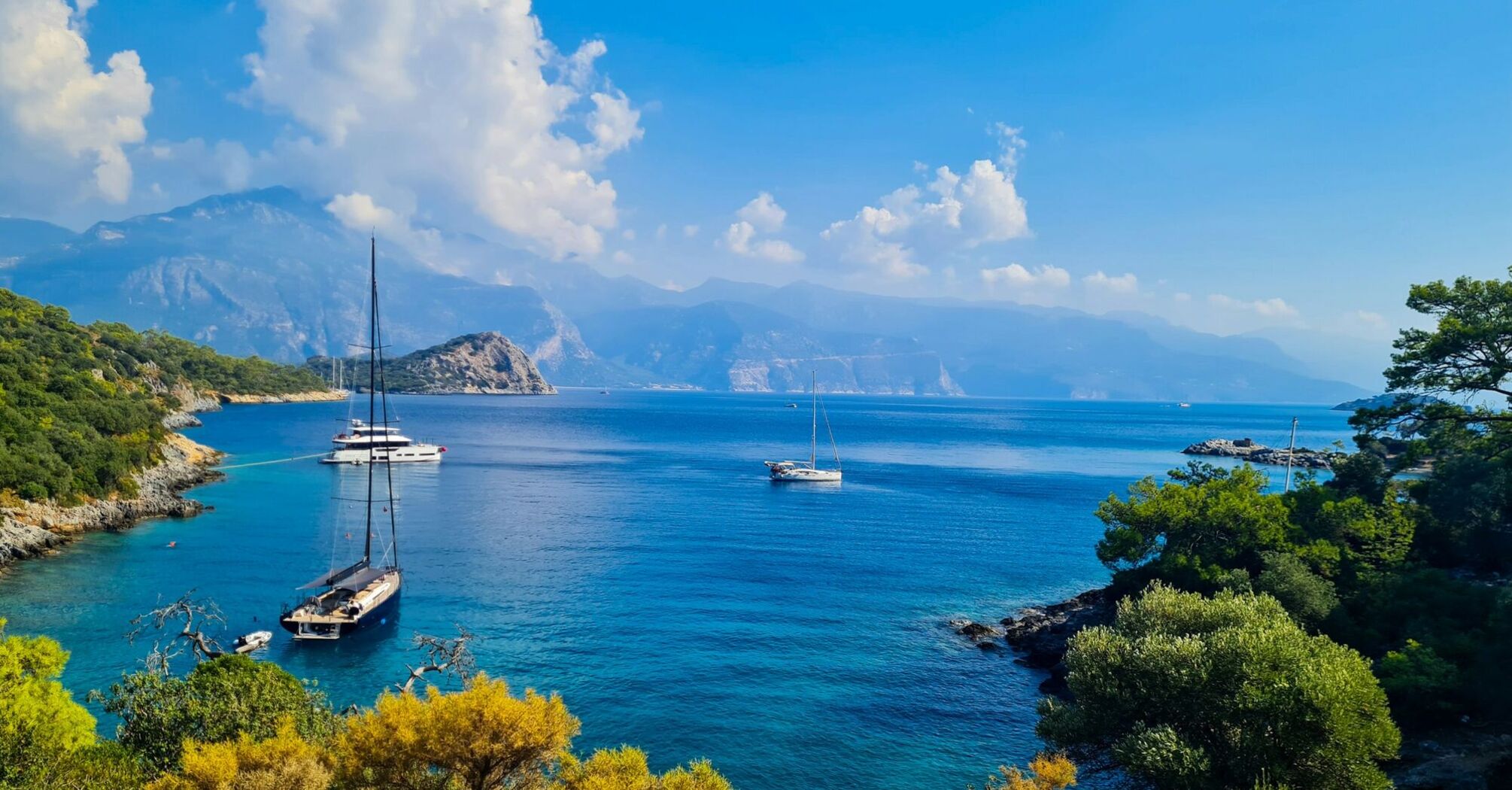 Sailboats anchored in a quiet turquoise bay on Turkey’s Mediterranean coast