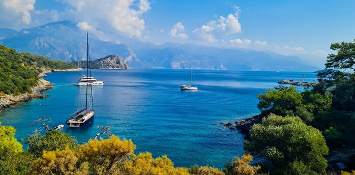 Sailboats anchored in a quiet turquoise bay on Turkey’s Mediterranean coast