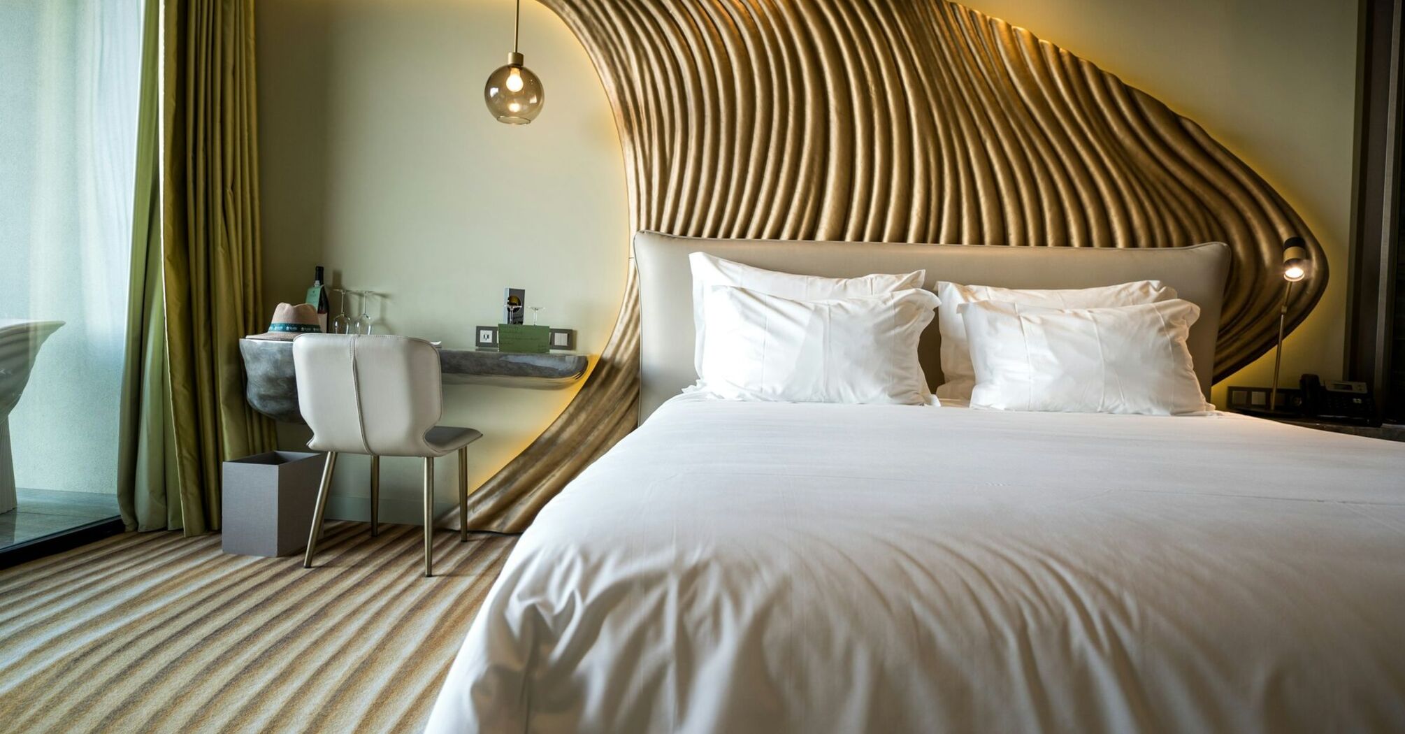 Hotel guest room with sculpted wooden headboard design