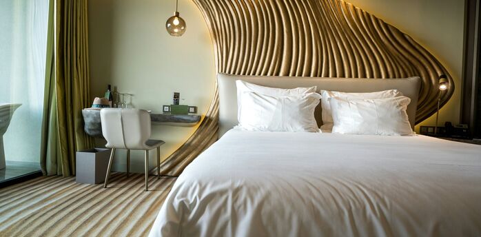 Hotel guest room with sculpted wooden headboard design