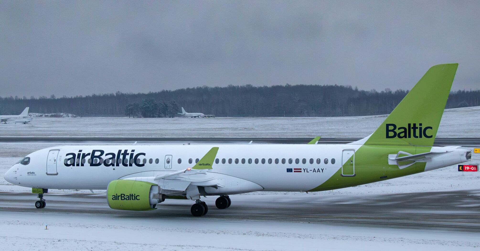airBaltic Airbus A220 aircraft on snowy runway