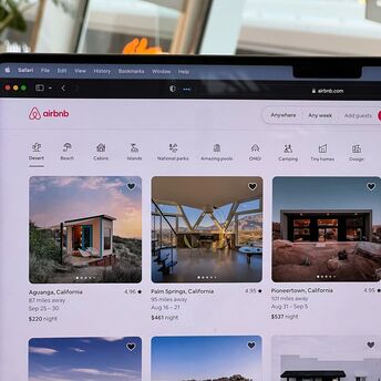 Airbnb listings displayed on a laptop screen during an online accommodation search