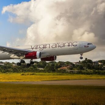 Virgin Atlantic aircraft flying above landscape during landing