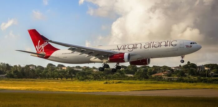 Virgin Atlantic aircraft flying above landscape during landing