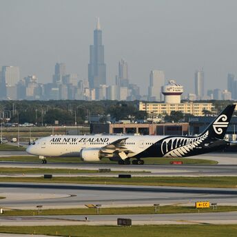 Air New Zealand Boeing 787-9 aircraft taxiing at airport with city skyline in background