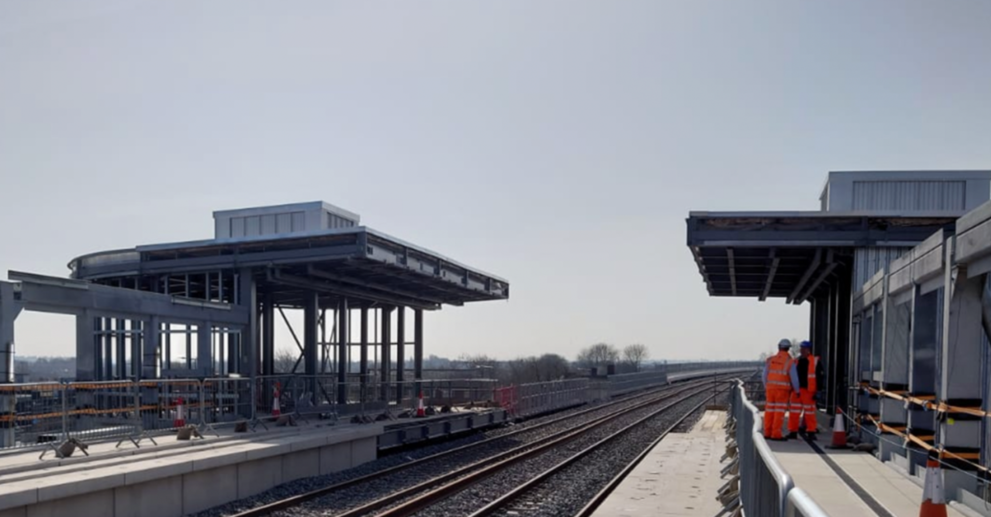 Newly built railway station platform with workers present