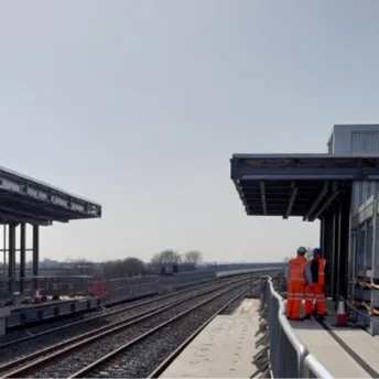 Newly built railway station platform with workers present