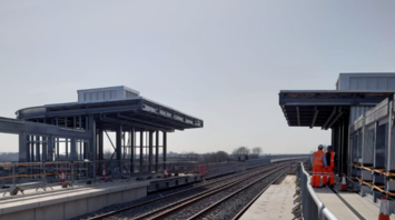 Newly built railway station platform with workers present