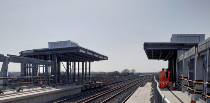 Newly built railway station platform with workers present