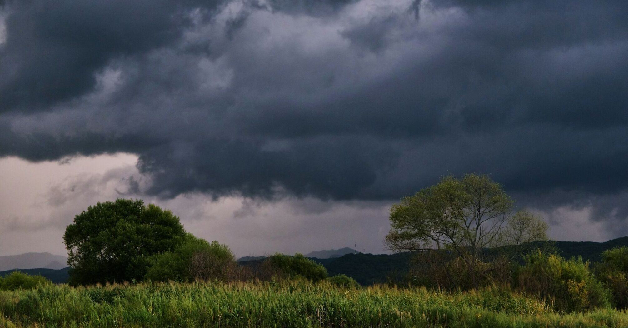 Dark storm clouds approaching rural landscape