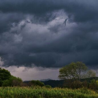 Dark storm clouds approaching rural landscape