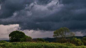 Dark storm clouds approaching rural landscape