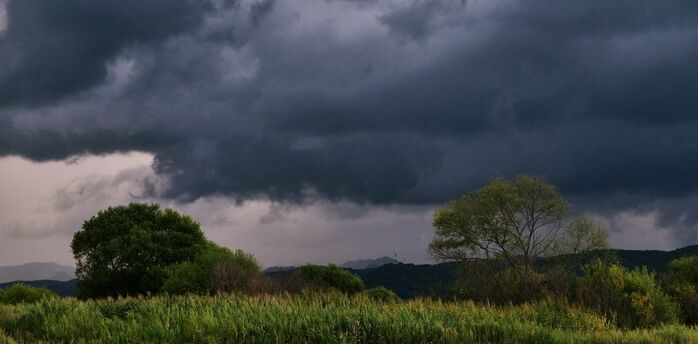 Dark storm clouds approaching rural landscape