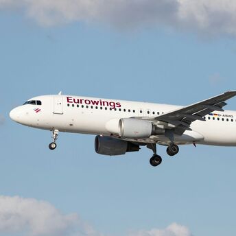 Eurowings passenger aircraft in flight against cloudy sky