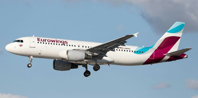 Eurowings passenger aircraft in flight against cloudy sky