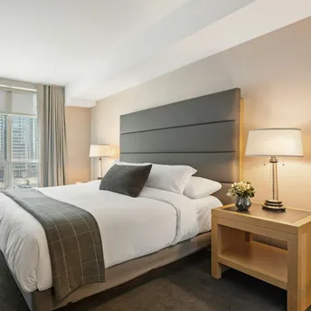 Modern hotel bedroom with large bed and city view window