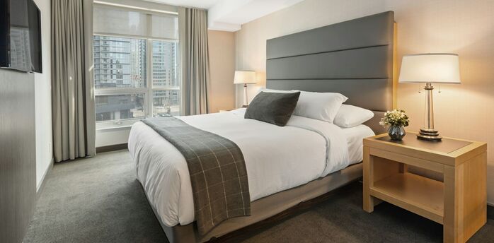 Modern hotel bedroom with large bed and city view window